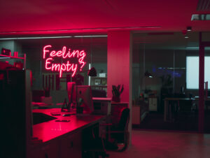 Dark office with neon "feeling empty" sign